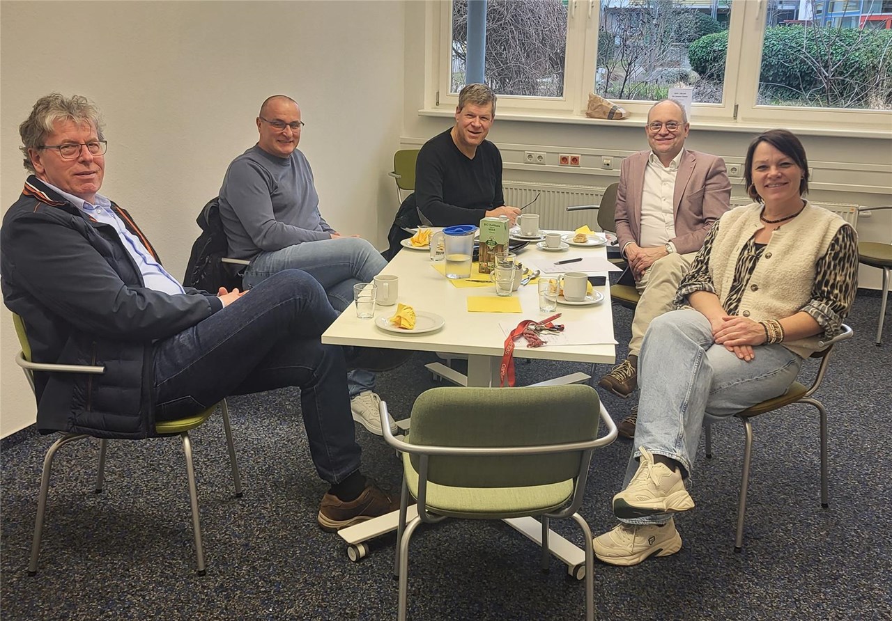 Verterter der Städtischen Wohnbau Emmendingen und der Caritas sitzen gemeinsam an einem Tisch.