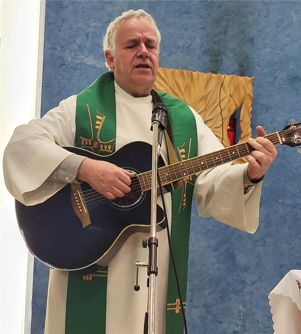 Pfarrer Rochlitz im Gottesdienst mit Gitarre