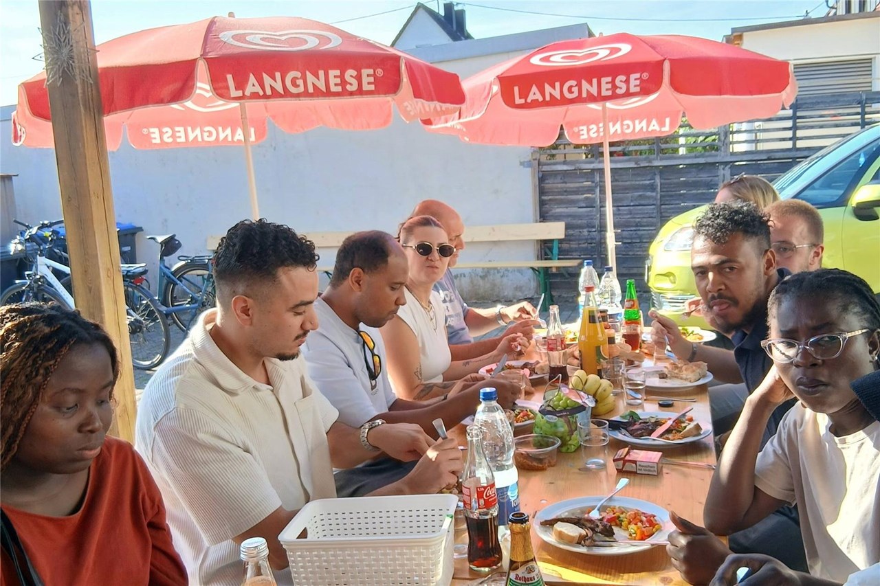 Einige der Azubis und FSJler*innen sitzen an einem Biertisch und essen gemeinsam.