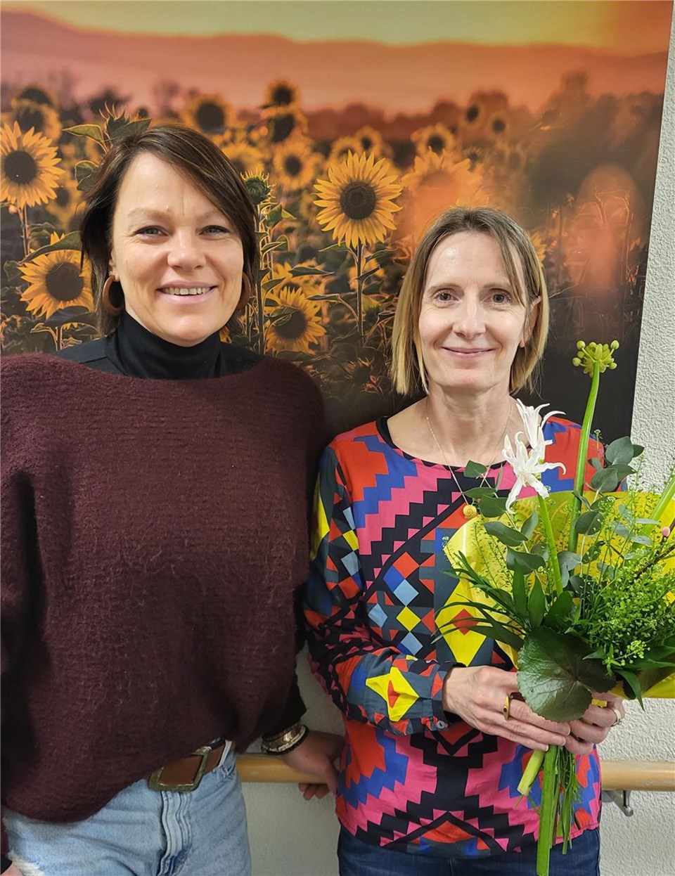 Frau Rambach, Leitung der Altenhilfe und Frau Balduin mit einem Blumenstrauß in der Hand.