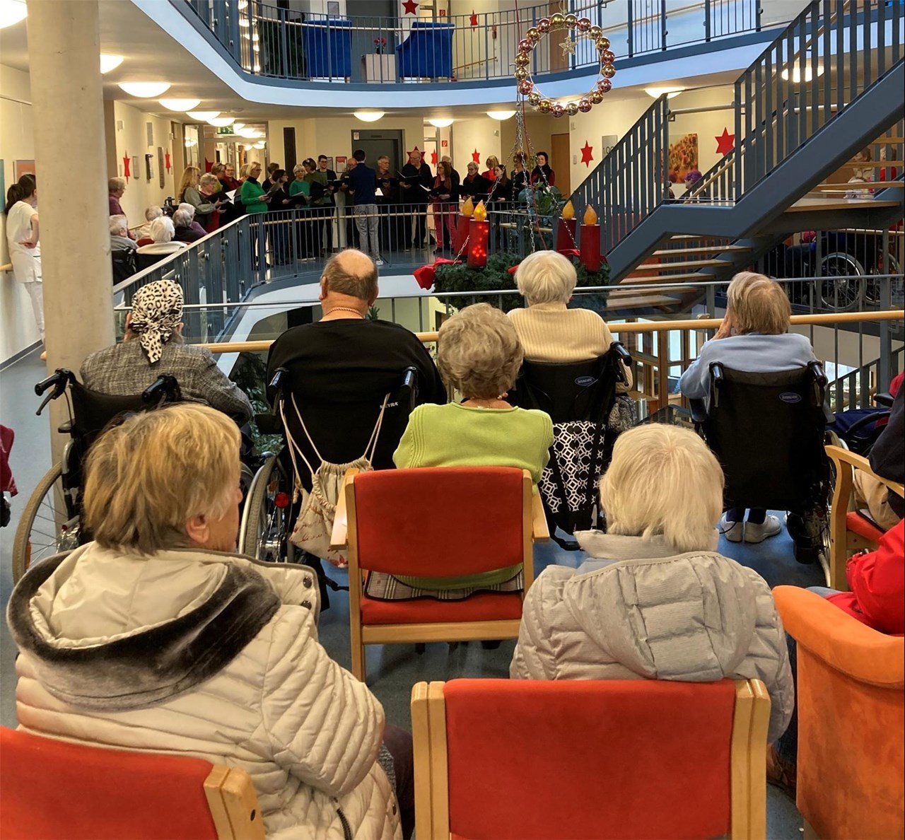 Im Seniorenzentrum Bürkle-Bleiche singt ein Chor, von hinten sind die Bewohner*innen zu sehen, die dem Chor zuhören.