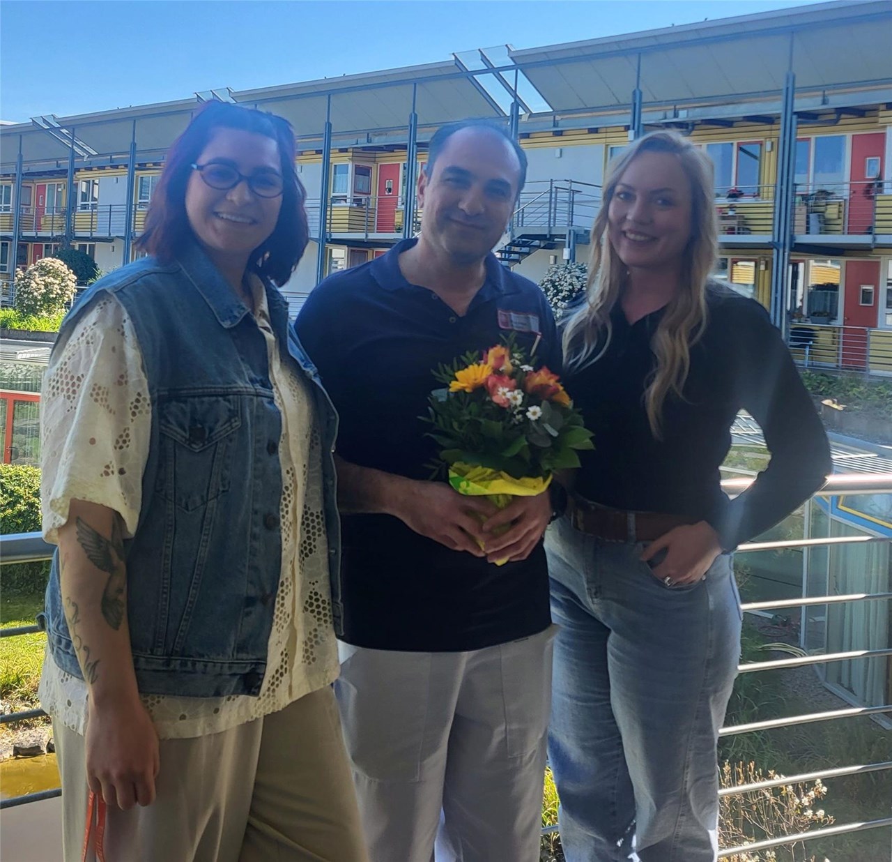 Lena Oberkirch-Forster, Pflegedienstleitung und Ines Hanselmann, Pflegefachliche Leitung im Seniorenzentrum Bürkle-Bleiche überreichen Simon Abbas einen Blumenstrauß