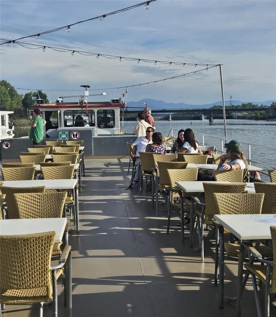 Bild vom oberen Deck eines Schiffes mit einigen Passieren, Blick auf den Rhein und das Ufer