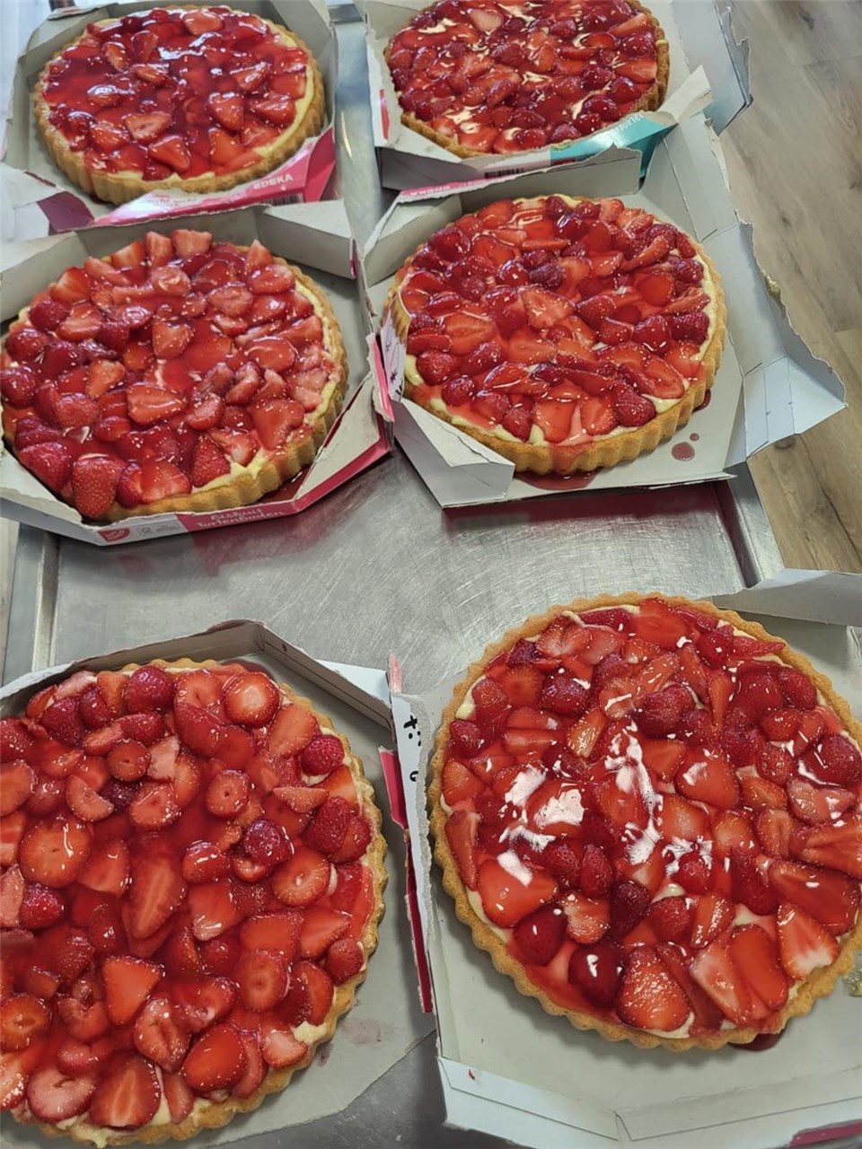 Eine Nahaufnahme von sechs Erdbeerkuchen nebeneinander.