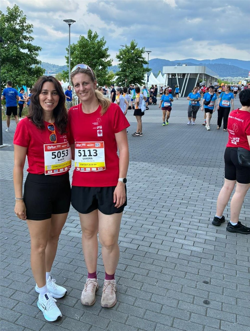 Zwei Mitarbeiterinnen des Caritasverbands Emmendingen in sportlicher Kleidung, roten T-Shirts und ihrer Laufnummer am T-Shirt schauen in die Kamera.