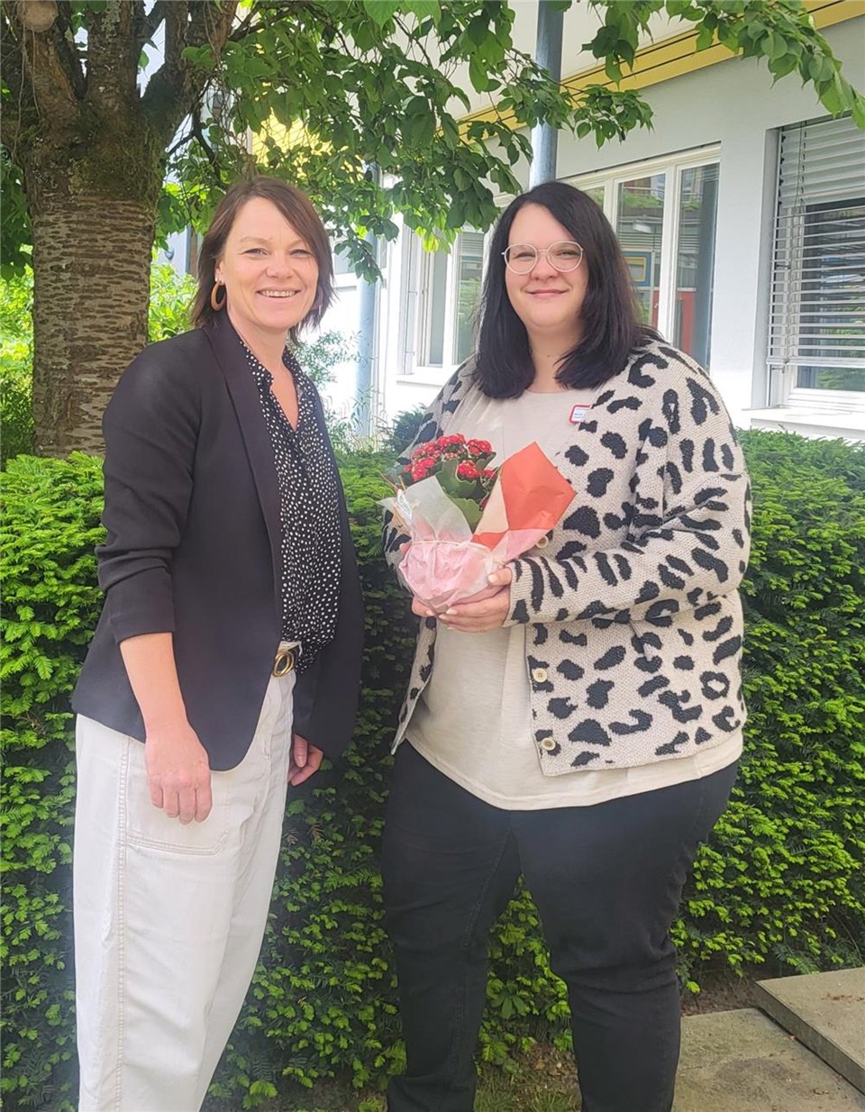 Zwei Personen, Katja Rambach, Bereichsleitung Altenhilfe und Nicole Gutjahr stehen nebeneinander, Frau Gutjahr hält Blumen in der Hand.