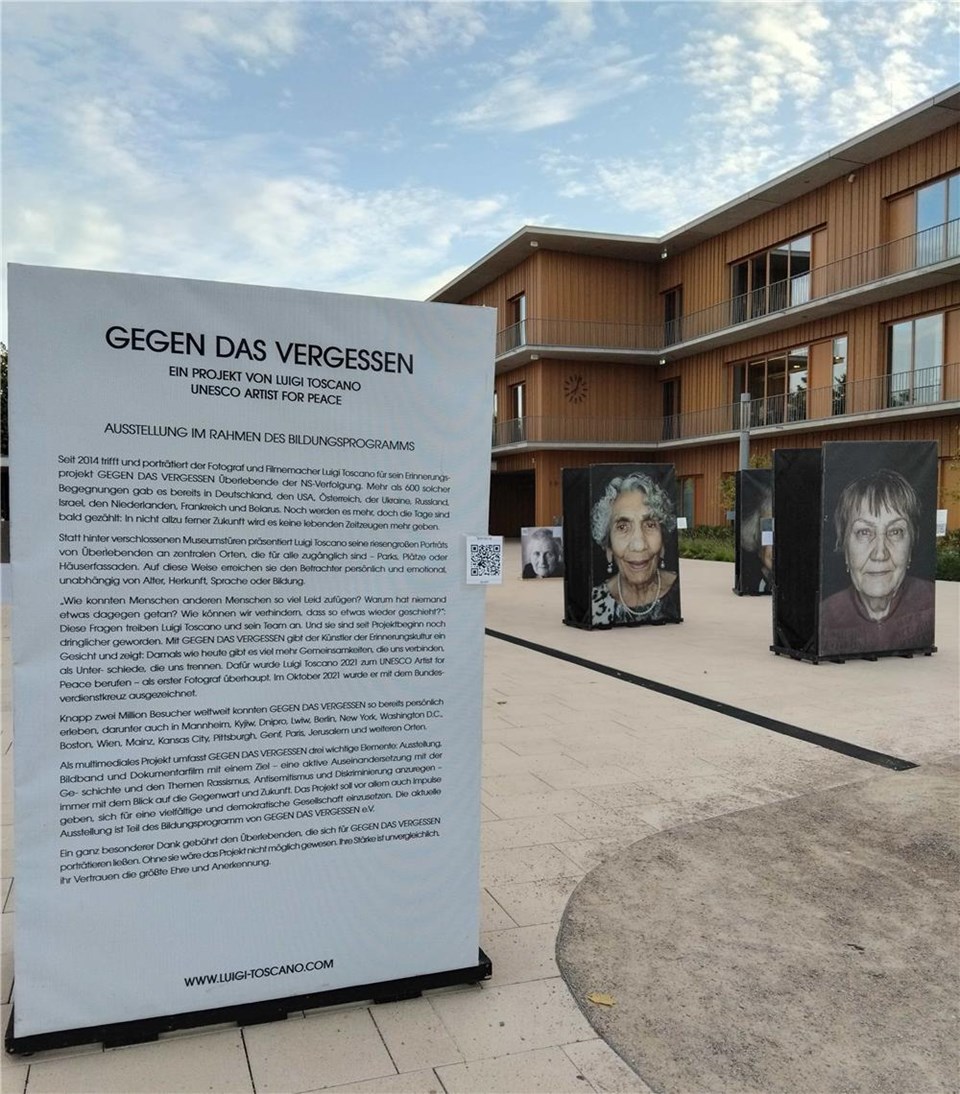 Schulhof mit den Portätfotos der Ausstellung und einem Aufsteller mit Erklärungen zur Ausstellung